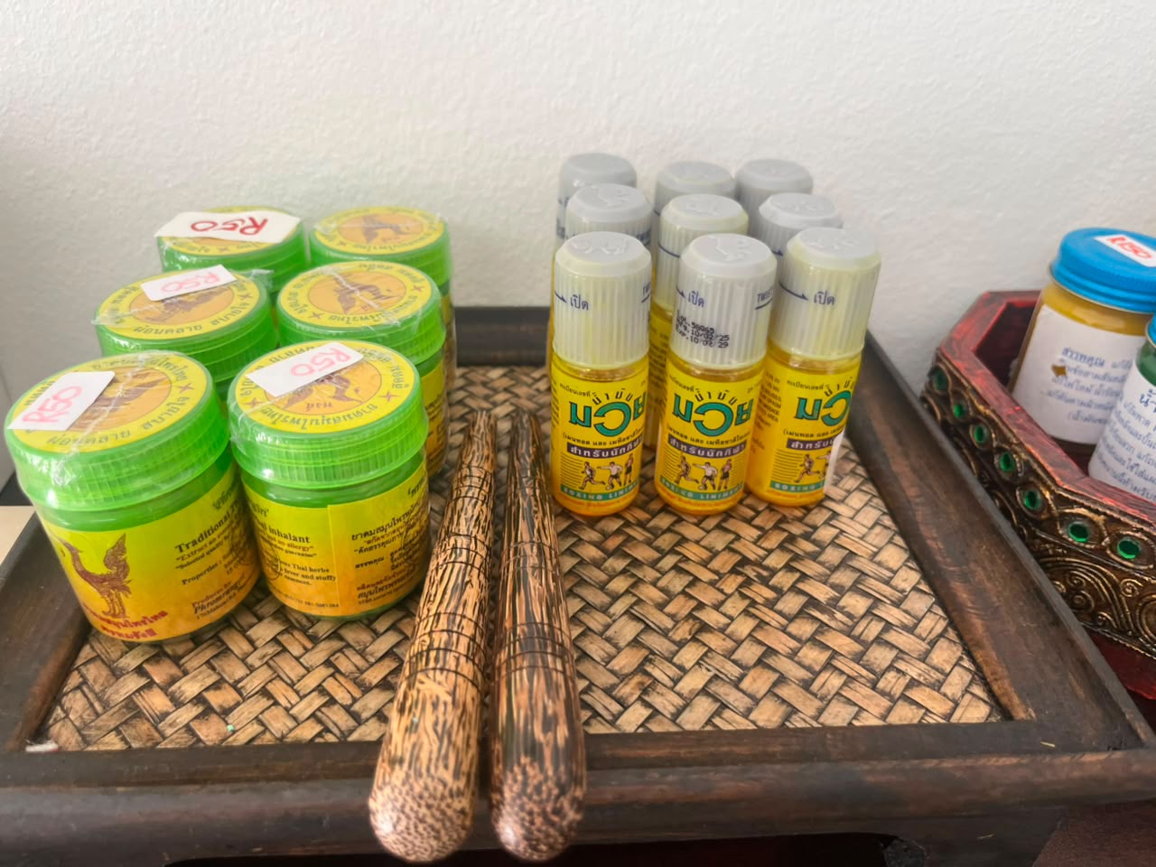 Thai massage balms and hand-carved wooden reflexology tools laid out for treatment